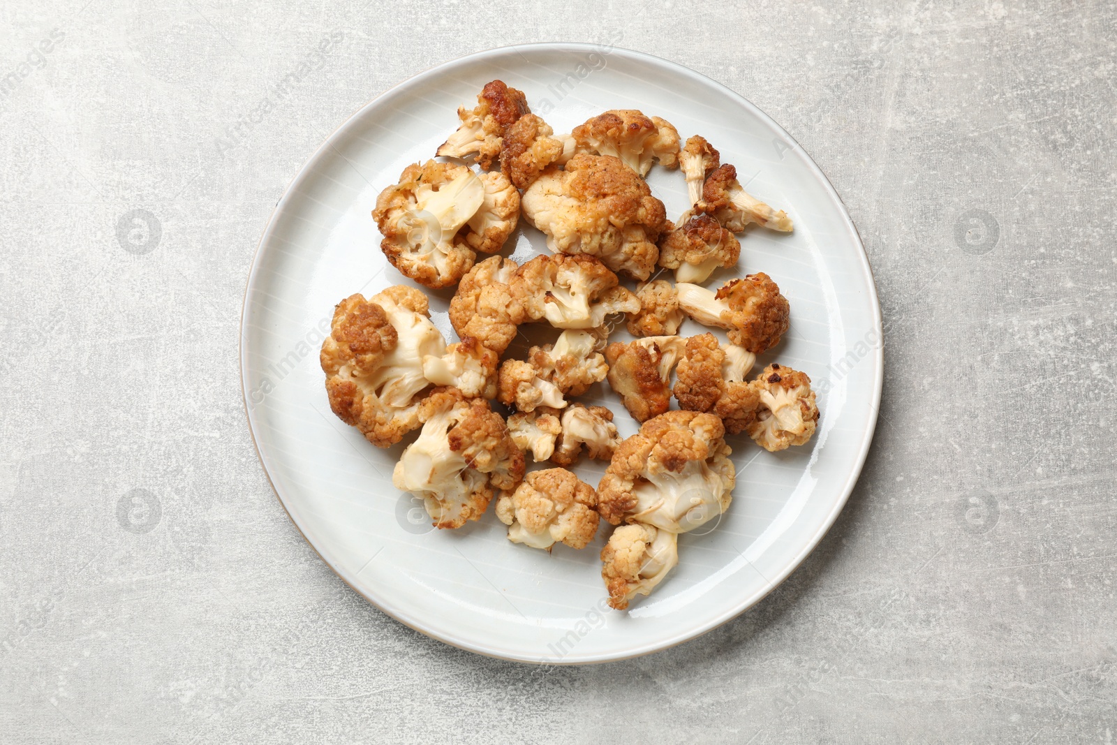 Photo of Baked cauliflower on light grey table, top view