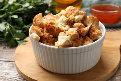 Baked cauliflower, sauce and products on wooden table