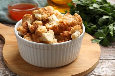 Baked cauliflower, sauce and products on wooden table