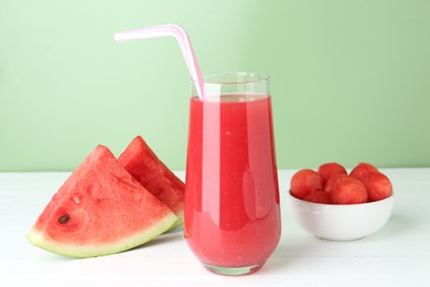 Photo of Tasty watermelon drink in glass and fresh fruit on white wooden table