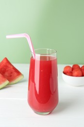 Photo of Tasty watermelon drink in glass and fresh fruit on white wooden table