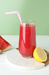 Photo of Tasty watermelon drink in glass and fresh fruits on white wooden table