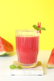 Photo of Tasty watermelon drink in glass and fresh fruit on white table