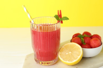 Photo of Tasty watermelon drink in glass and fresh fruits on white table, closeup