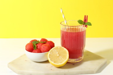 Photo of Tasty watermelon drink in glass and fresh fruits on white table