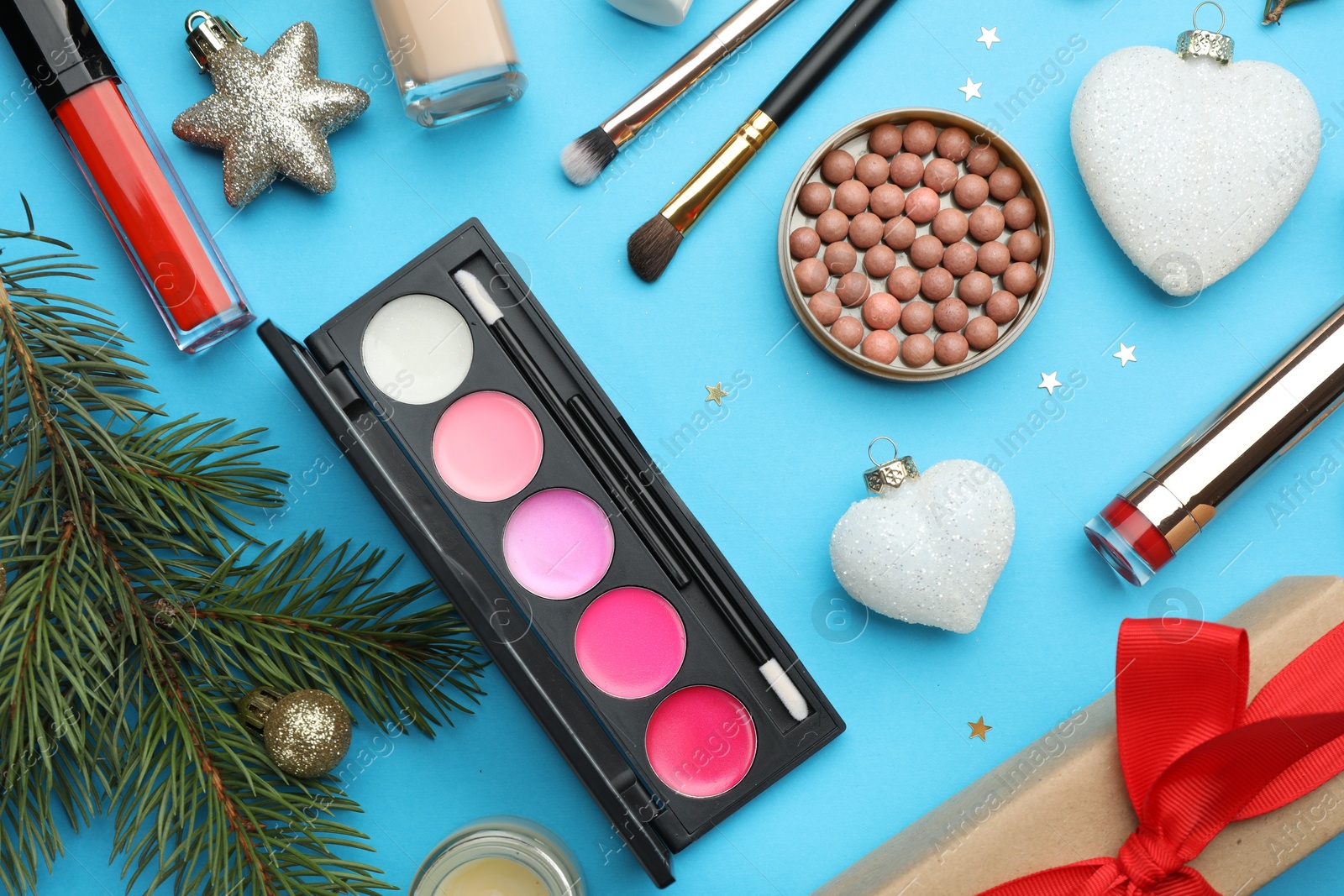 Photo of Flat lay composition with makeup products and Christmas decor on light blue background