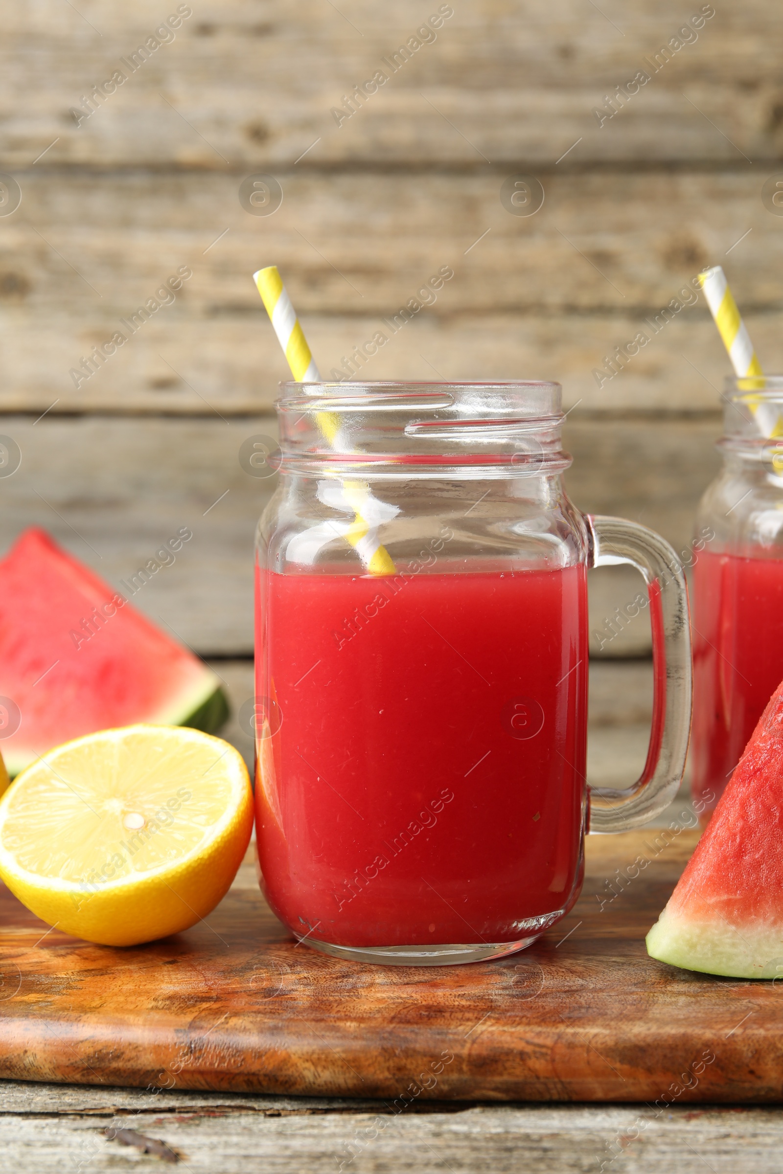 Photo of Tasty watermelon drink in mason jars and fresh fruits on wooden table