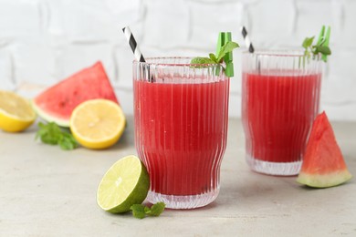 Photo of Delicious watermelon drink in glasses and fresh fruits on light table