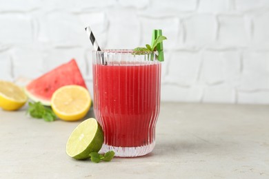 Photo of Delicious watermelon drink in glass and fresh fruits on light table