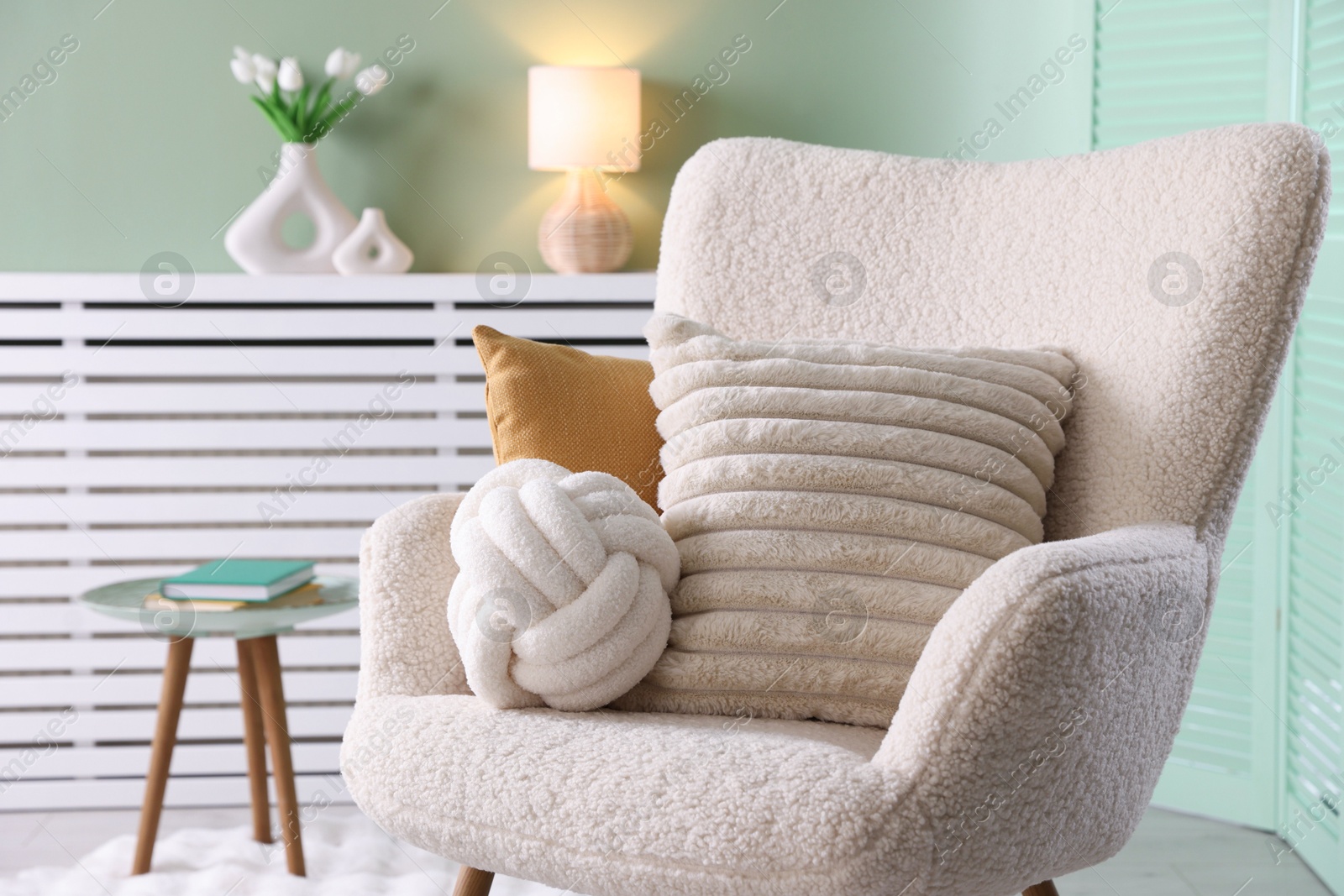 Photo of Decorative pillows on light armchair in living room