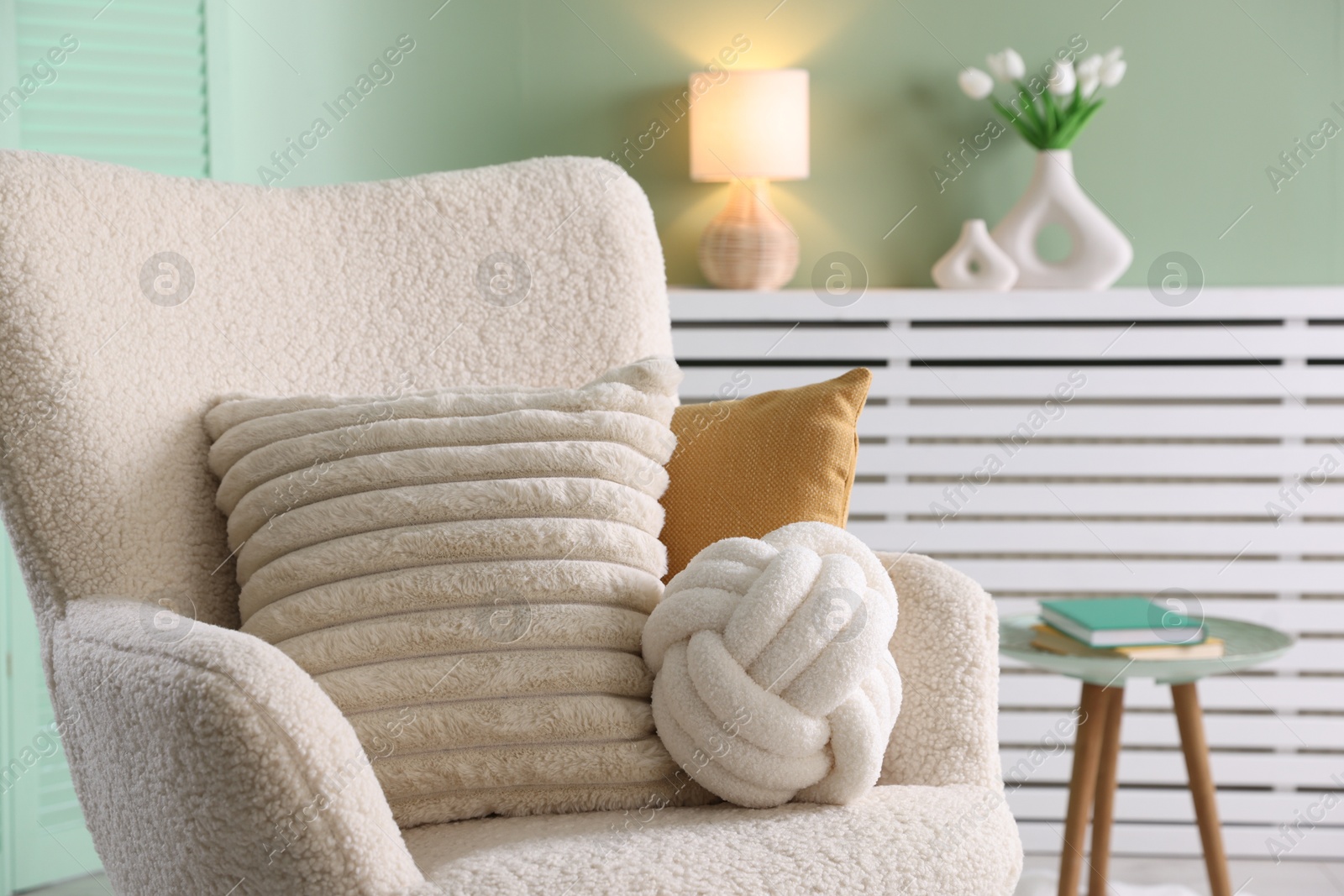 Photo of Decorative pillows on light armchair in living room