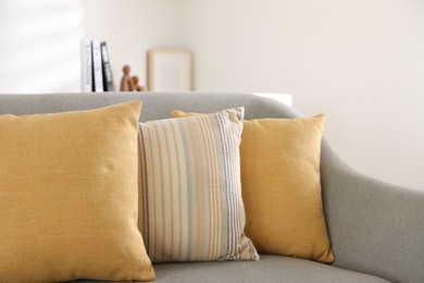 Photo of Different soft pillows on gray sofa in living room