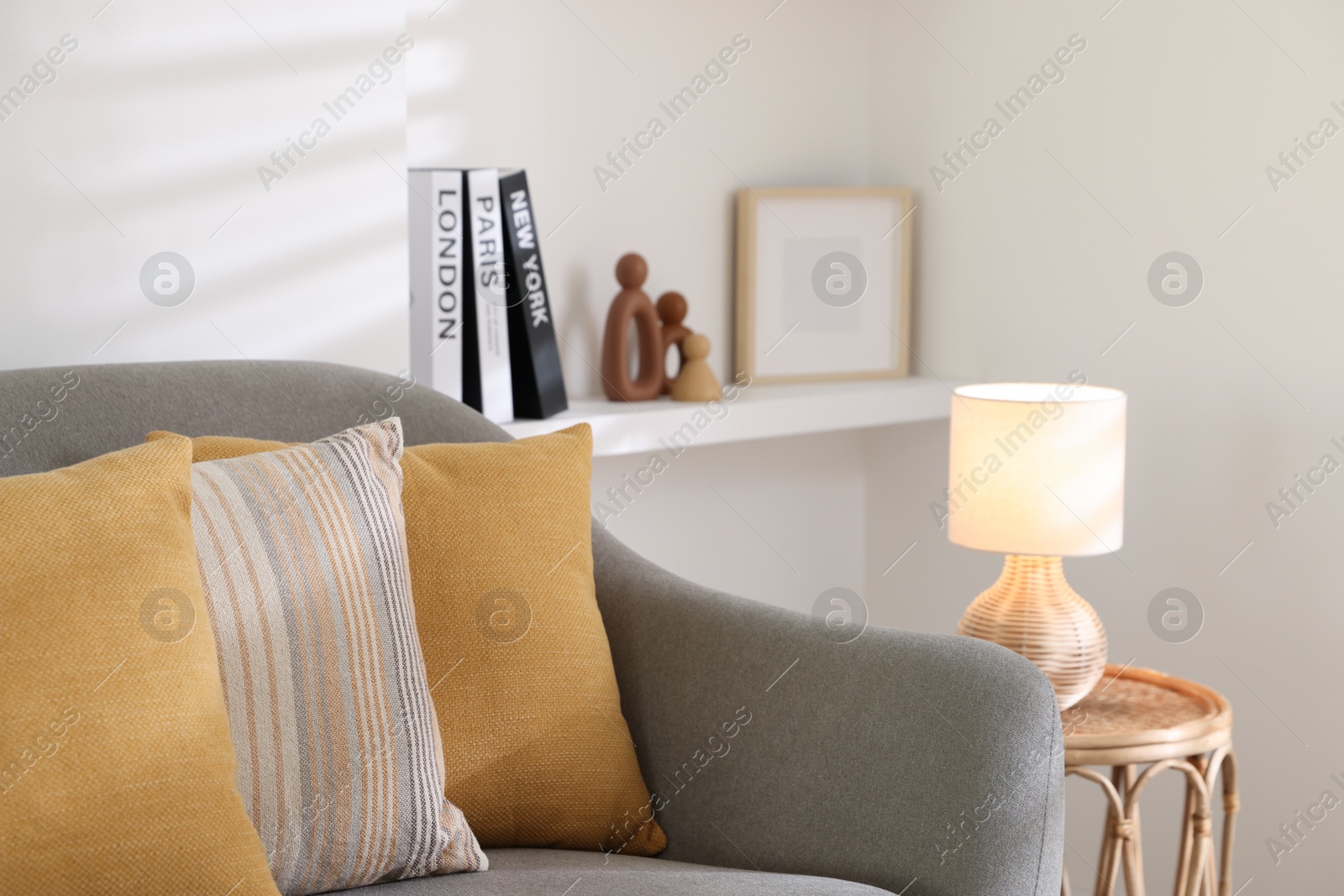 Photo of Different soft pillows on gray sofa in living room