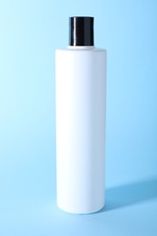 Photo of Shampoo in bottle on light blue background. Personal care product