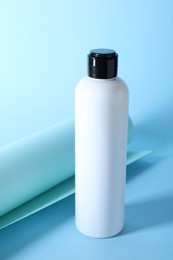 Shampoo in bottle on light blue background. Personal care product