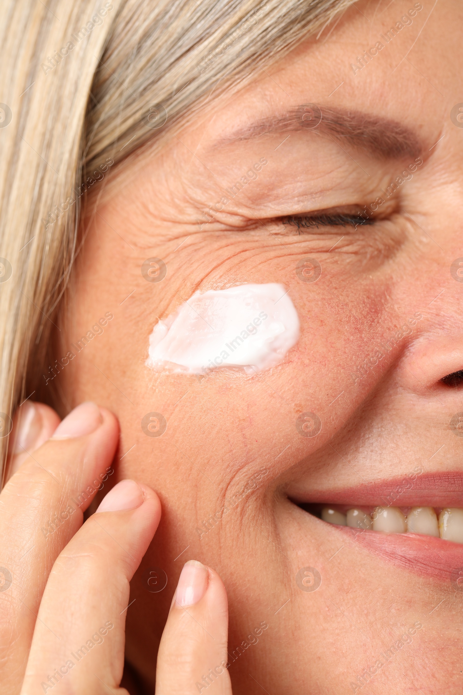 Photo of Senior woman with cream on face, closeup