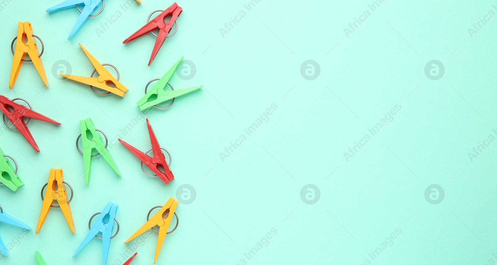 Photo of Many colorful clothespins on turquoise background, flat lay. Space for text