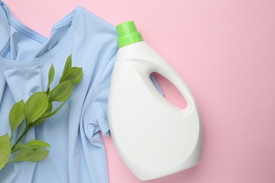 Photo of Bottle of laundry detergent, t-shirt and green branch on pink background, flat lay