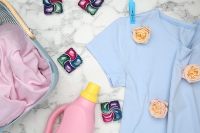 Photo of Flat lay composition with laundry detergents, rose flowers and t-shirts on white marble table