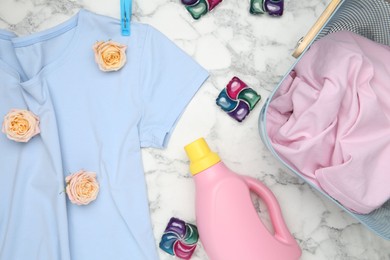 Photo of Flat lay composition with laundry detergents, rose flowers and t-shirts on white marble table