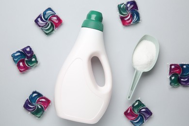 Photo of Different laundry detergents on grey table, flat lay