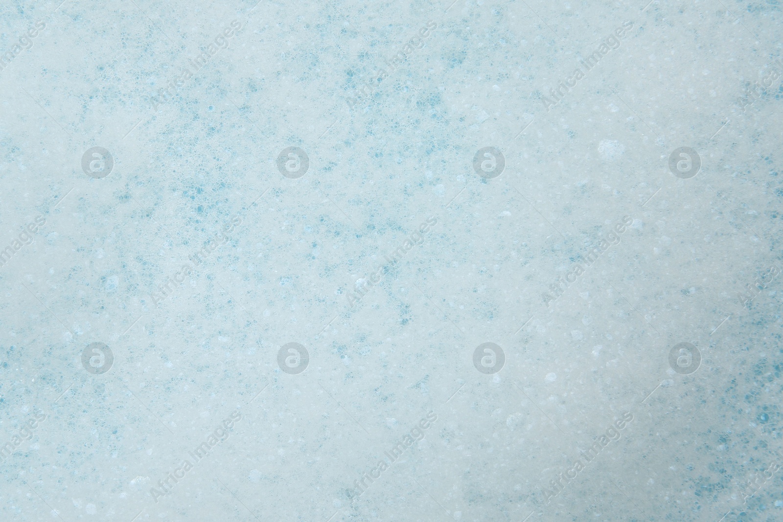 Photo of Washing laundry. White foam with bubbles as background, top view