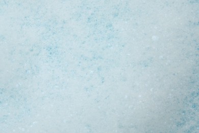 Photo of Washing laundry. White foam with bubbles as background, top view