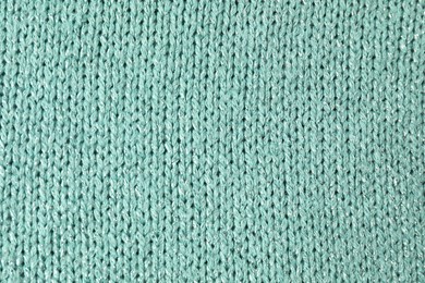 Photo of Texture of turquoise knitted fabric as background, top view