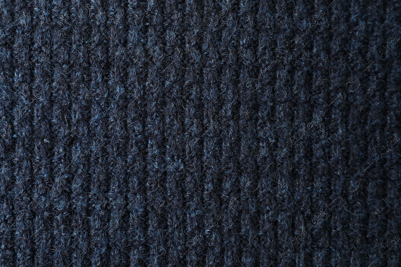 Photo of Texture of dark blue knitted fabric as background, top view