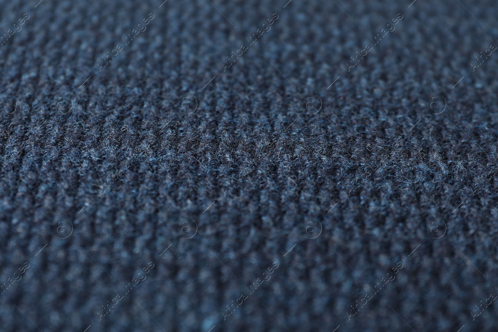 Photo of Texture of dark blue knitted fabric as background, closeup