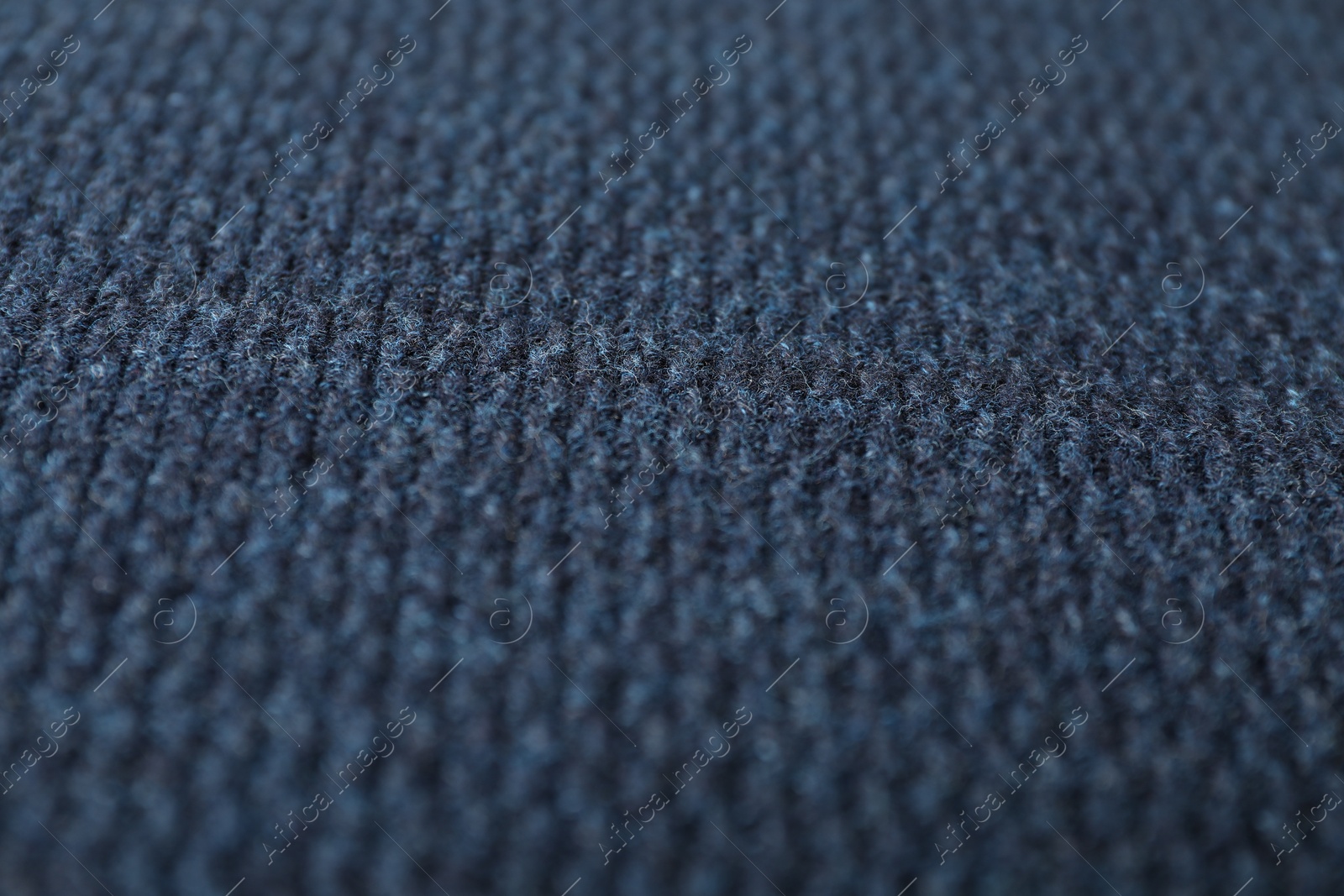 Photo of Texture of dark blue knitted fabric as background, closeup