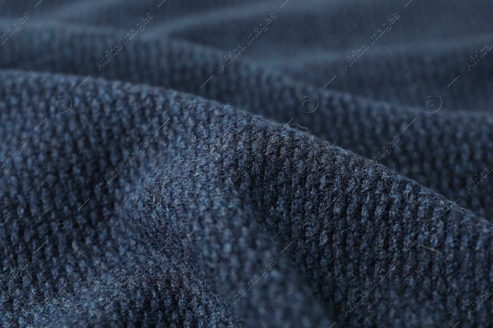 Photo of Texture of dark blue knitted fabric as background, closeup