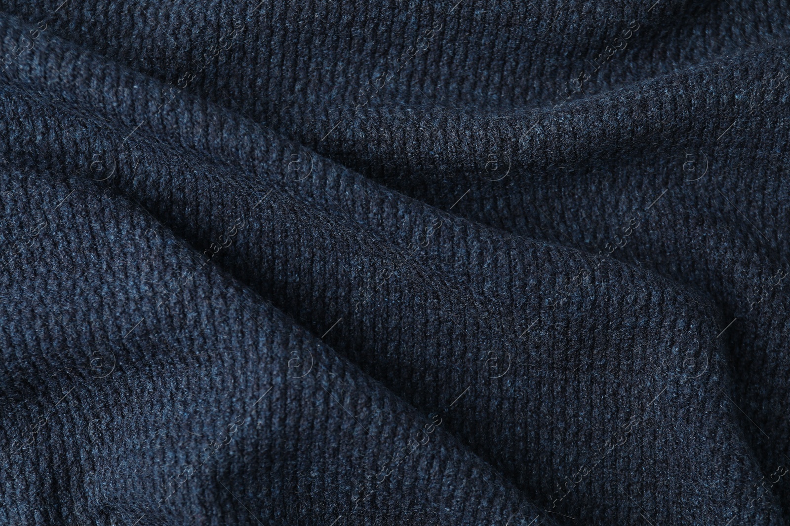 Photo of Texture of dark blue knitted fabric as background, closeup