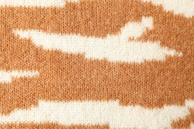 Photo of Texture of bright knitted fabric with pattern as background, top view