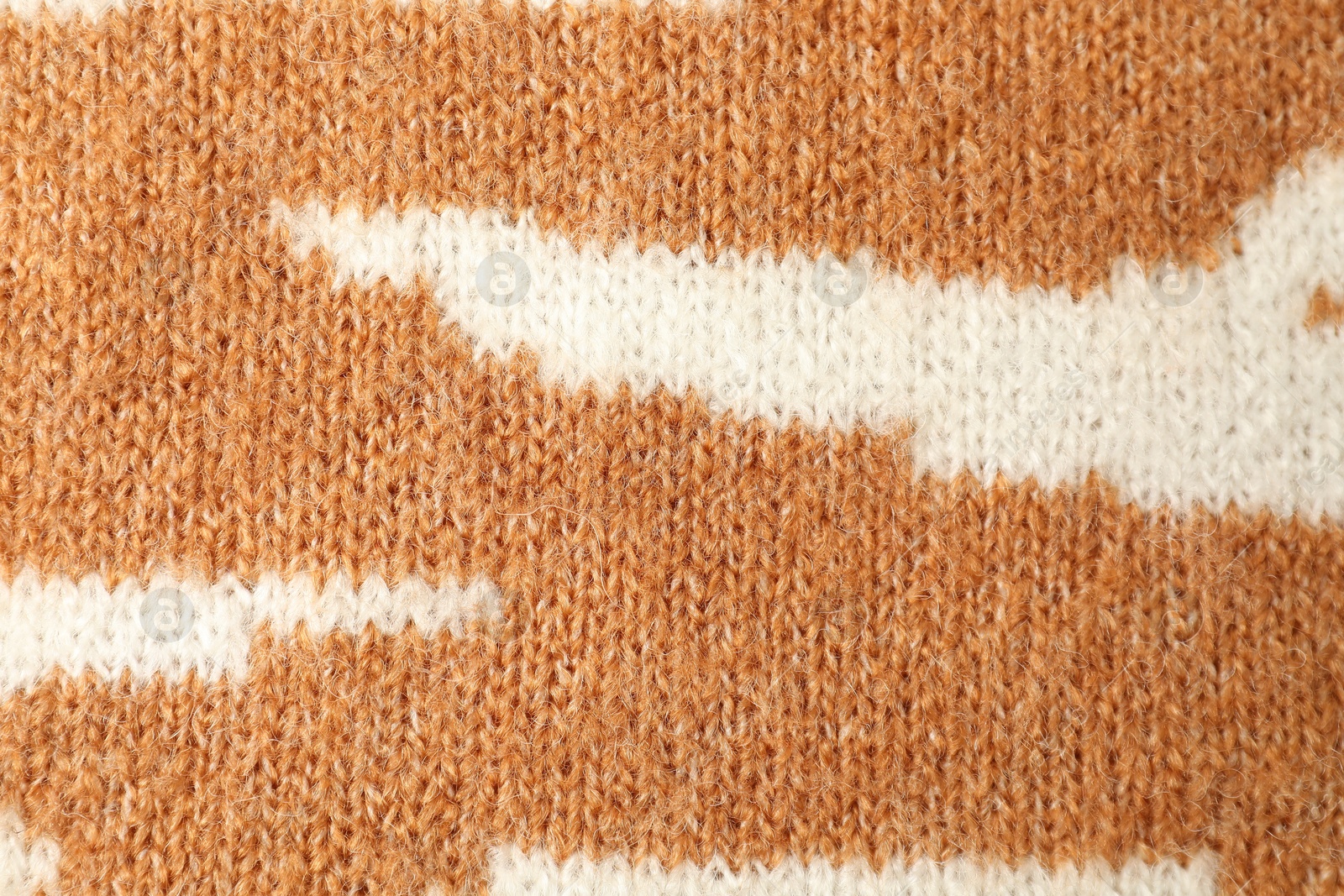 Photo of Texture of bright knitted fabric with pattern as background, top view