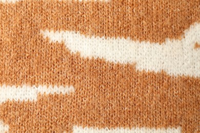 Photo of Texture of bright knitted fabric with pattern as background, top view