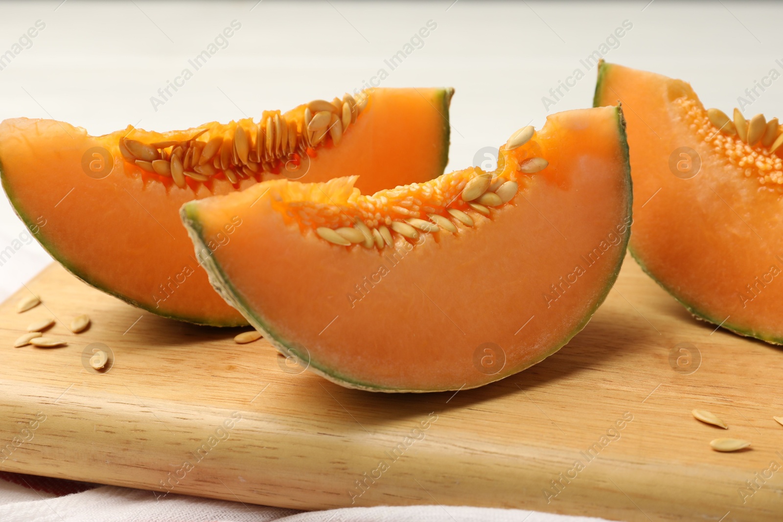 Photo of Cut ripe Cantaloupe melon on white table, closeup