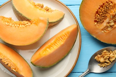 Photo of Cut ripe Cantaloupe melon and spoon with seeds on light blue wooden table, flat lay