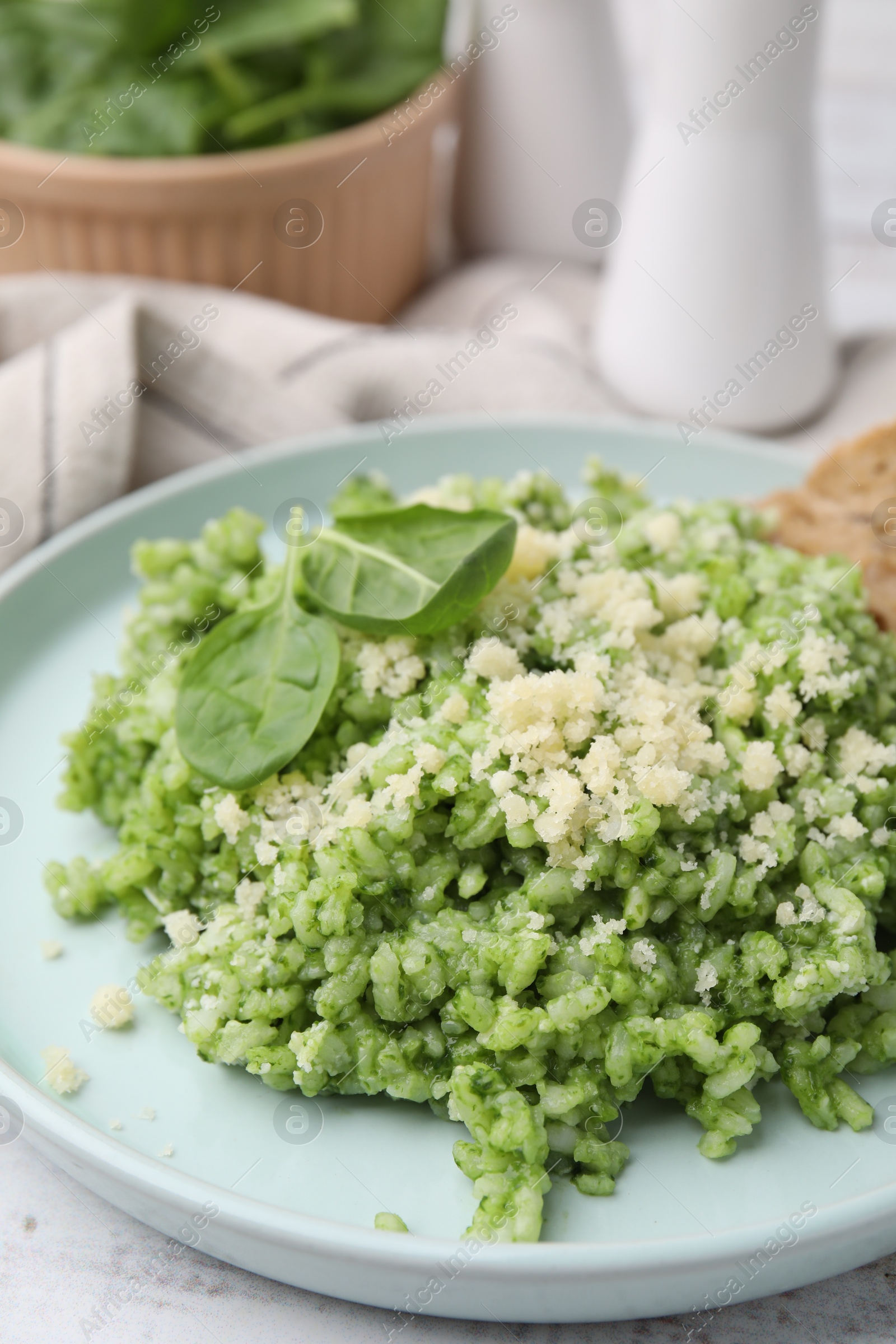 Photo of Tasty spinach risotto served with bread on white wooden table, closeup