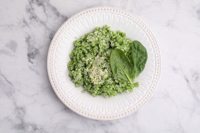 Photo of Tasty spinach risotto served on white marble table, top view