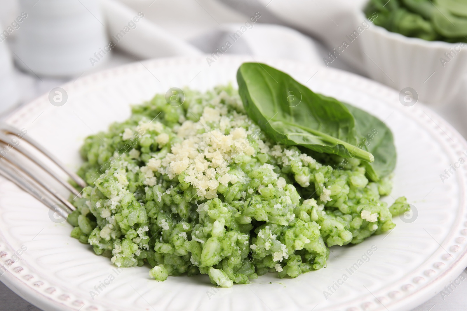 Photo of Tasty spinach risotto served on table, closeup