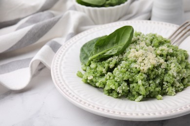 Photo of Tasty spinach risotto served on white marble table, closeup