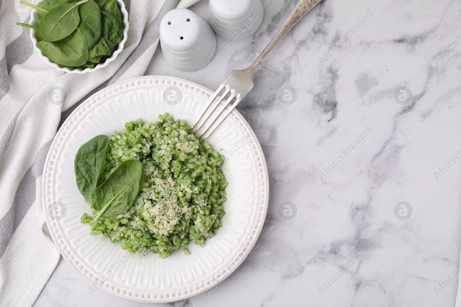 Photo of Tasty spinach risotto served on white marble table, flat lay. Space for text