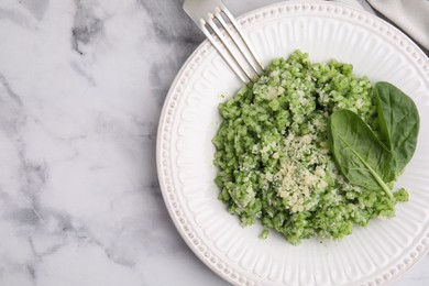 Photo of Tasty spinach risotto served on white marble table, top view. Space for text