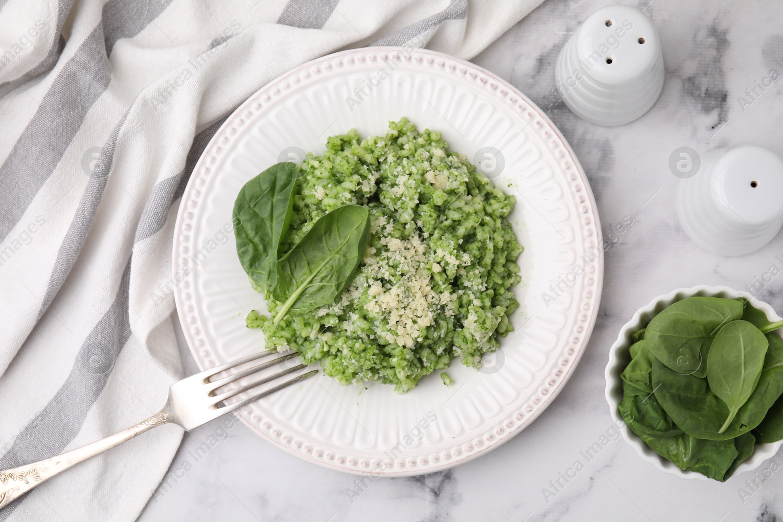 Photo of Tasty spinach risotto served on white marble table, flat lay