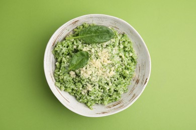 Photo of Tasty spinach risotto on light green background, top view