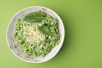 Photo of Tasty spinach risotto on light green background, top view. Space for text