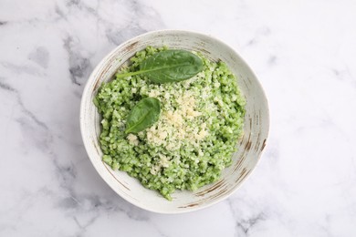 Photo of Tasty spinach risotto served on white marble table, top view