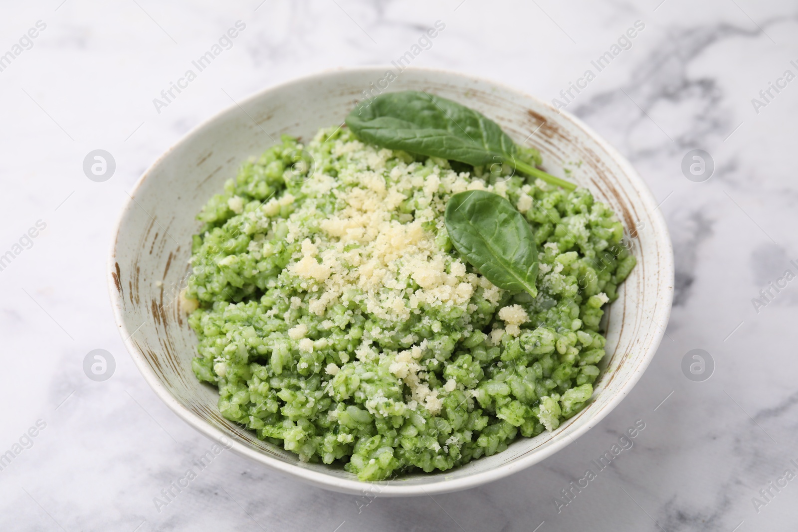 Photo of Tasty spinach risotto served on white marble table, closeup