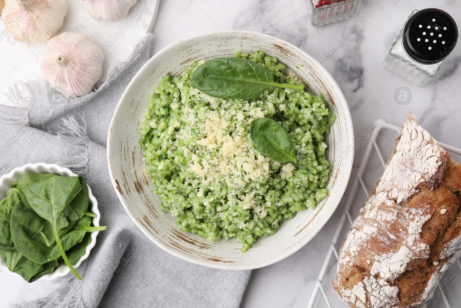 Photo of Tasty spinach risotto served on white marble table, flat lay